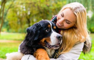 Frau beim Kuscheln mit Hund